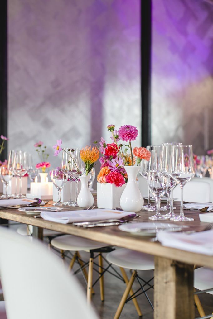 Blumen in pink und orange auf den Tischen - Photo by Hanna Witte