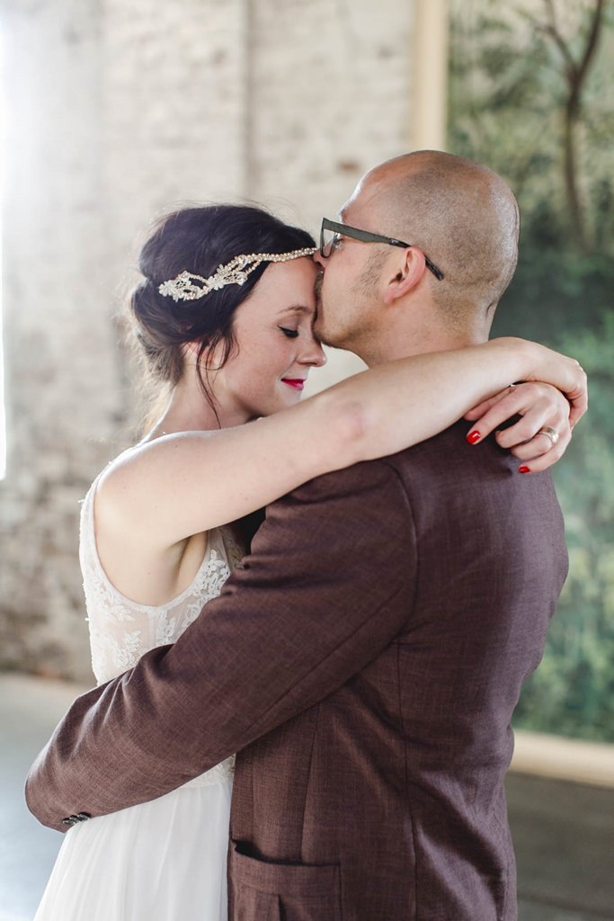 Bräutigam küsst die Braut liebevoll auf die Stirn