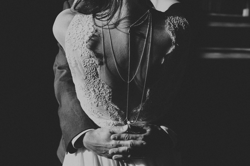 Rückenansicht der Braut während sie den Bräutigam umarmt
