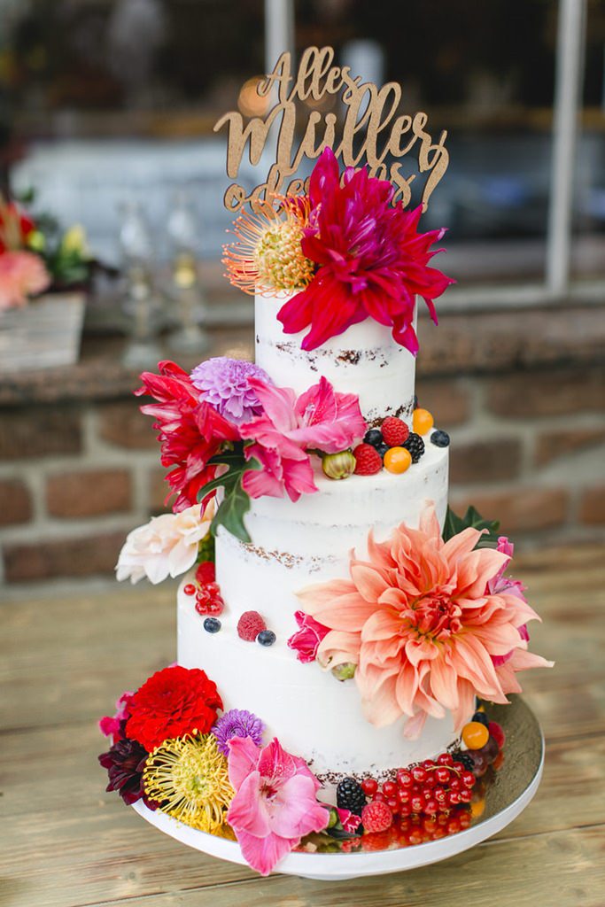 sommerliche semi naked cake Hochzeitstorte mit bunter Blütendeko