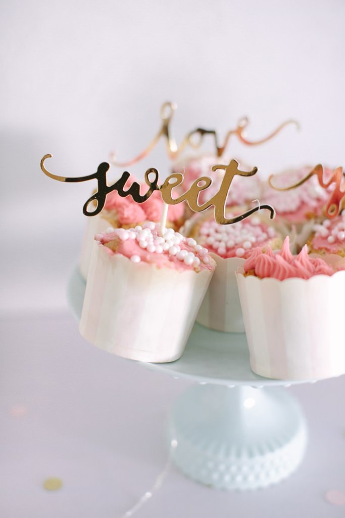 rosafarbene Hochzeits-Cupcakes mit weißen Perlen und goldenen Cupcake Toppern