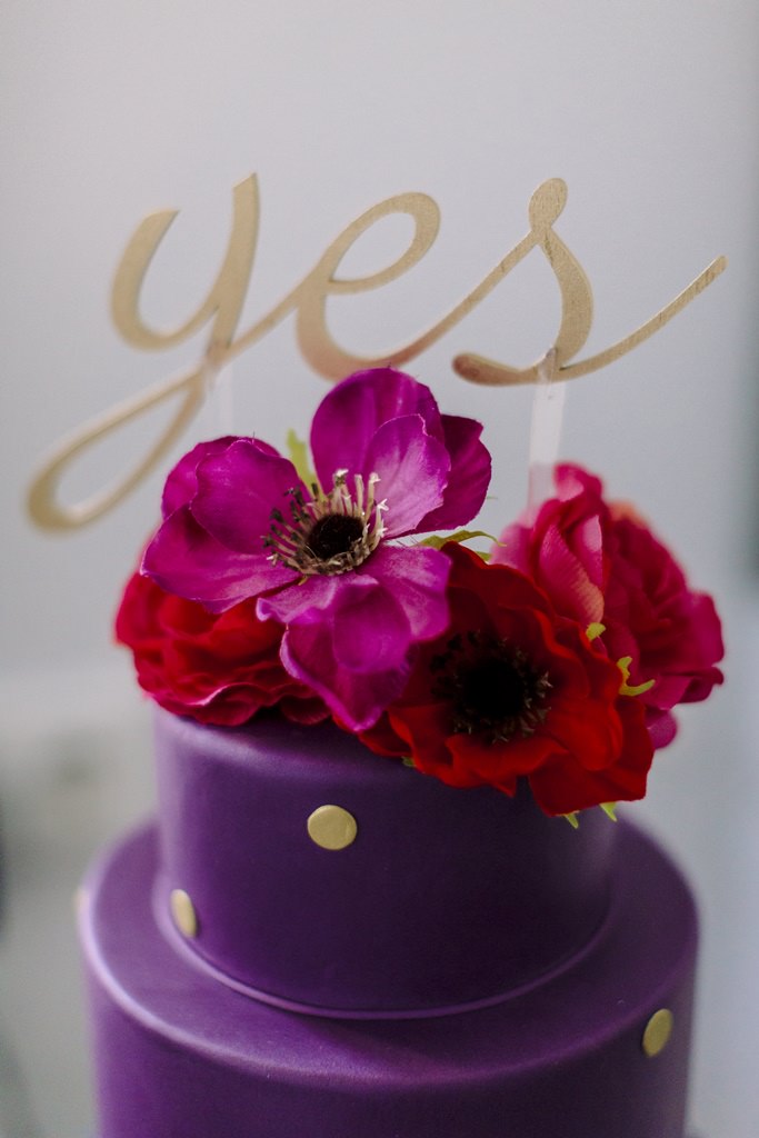 goldener Yes Cake Topper auf einer lila Hochzeitstorte