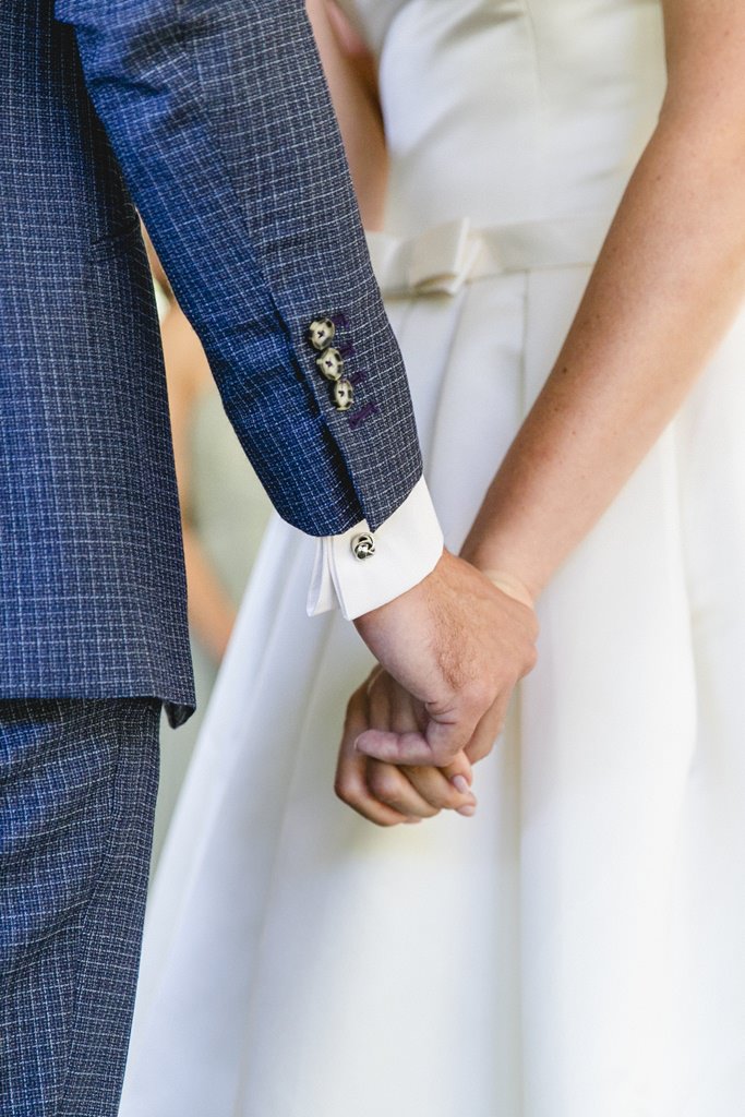 Hochzeitsfoto Idee für die Trauung: Braut und Bräutigam halten sich an den Händen