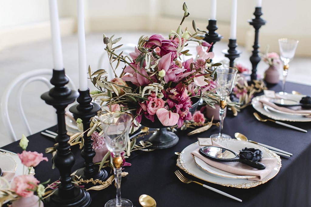 eleganter Hochzeitstisch mit Dekoelementen in Schwarz, Rosa und Gold