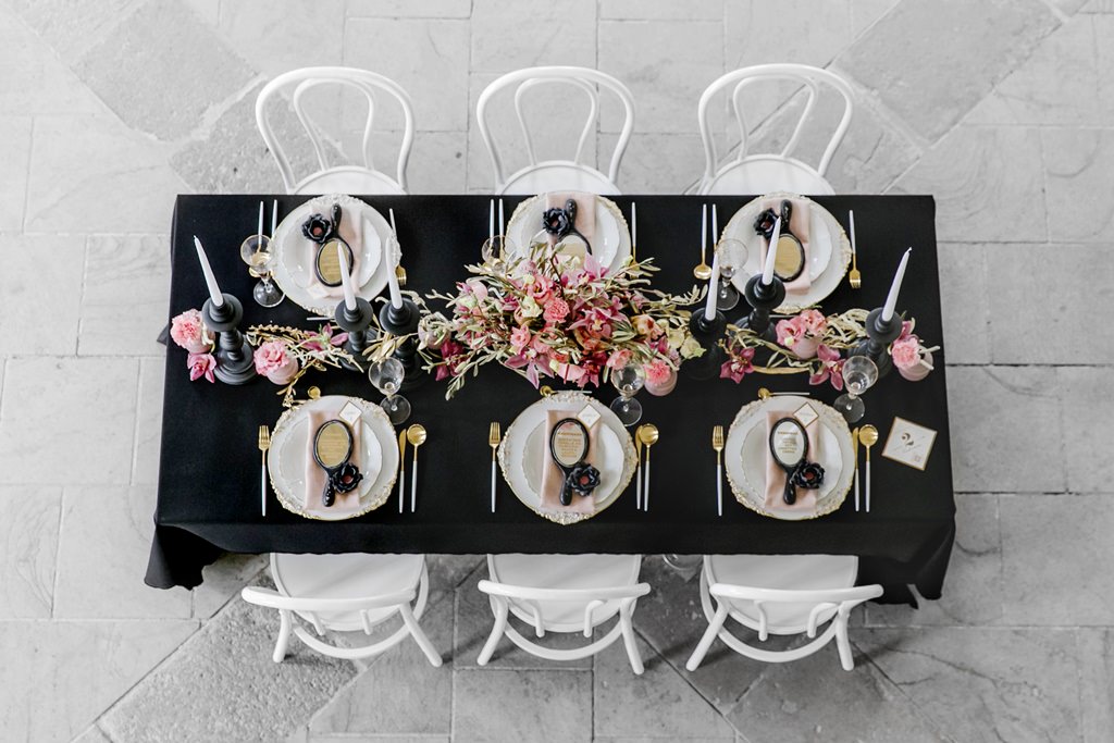 ein von oben fotografierter Tisch mit einer Hochzeitsdekoration in schwarz