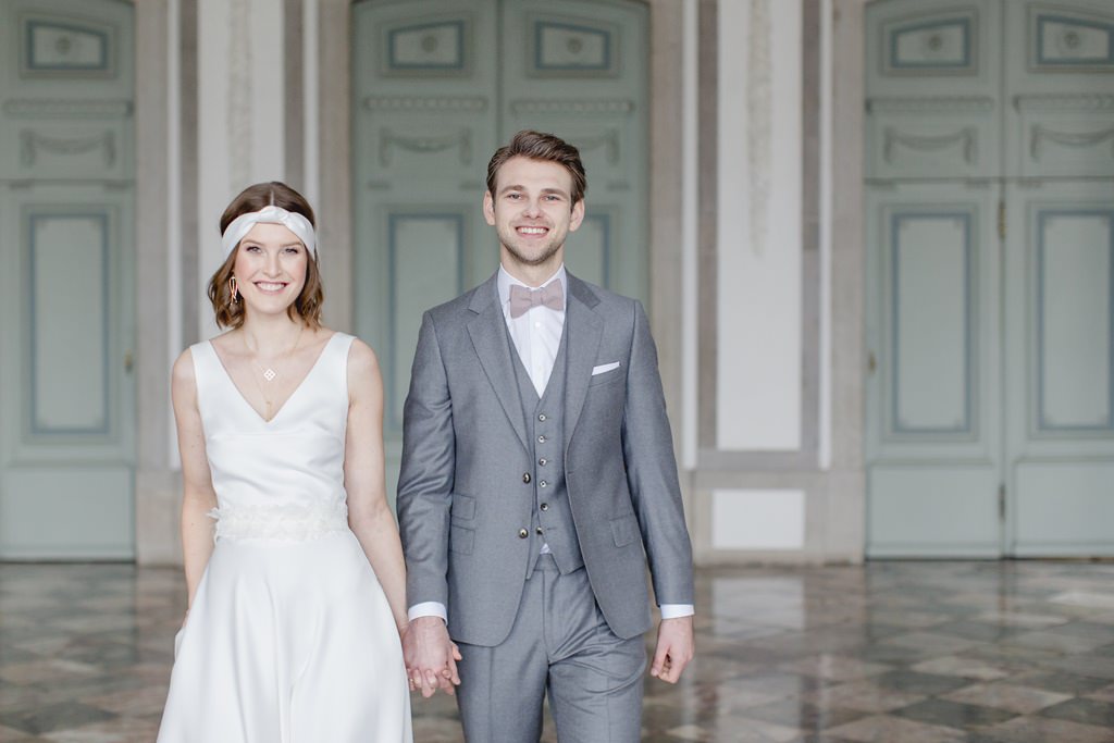 Hochzeitsfotoidee Braut und Bräutigam Hand in Hand auf Schloss Benrath