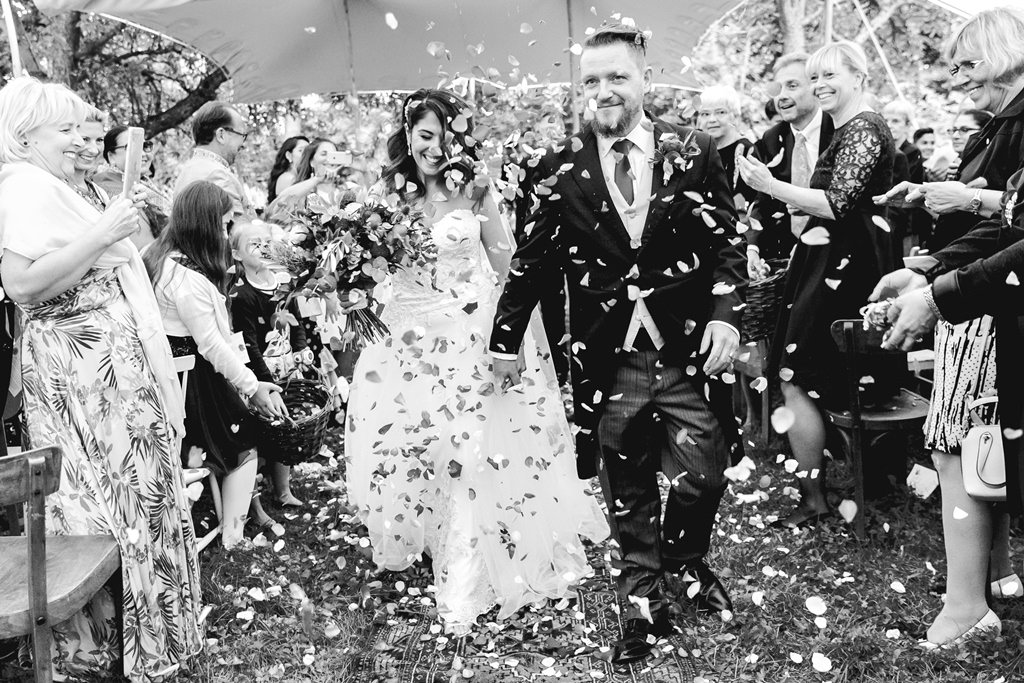 Hochzeitsfoto Idee: Das Brautpaar wird nach der Trauung von den Gästen mit Konfetti beworfen