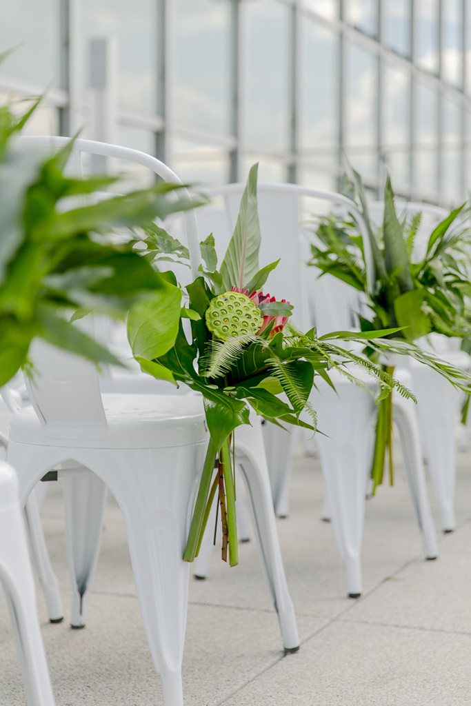tropische Blumen und Blätter schmücken die Stühle bei einer Freien Trauung | Foto von Hanna Witte Hochzeitsreportagen