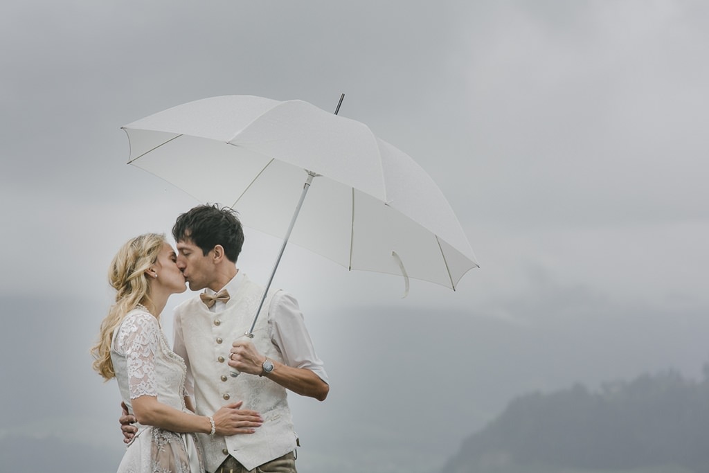 Braut und Bräutigam küssen sich unter einem Regenschirm | Foto aufgenommen beim Hochzeitsfotografie Workshop von Fotografin Hanna Witte für den bpp