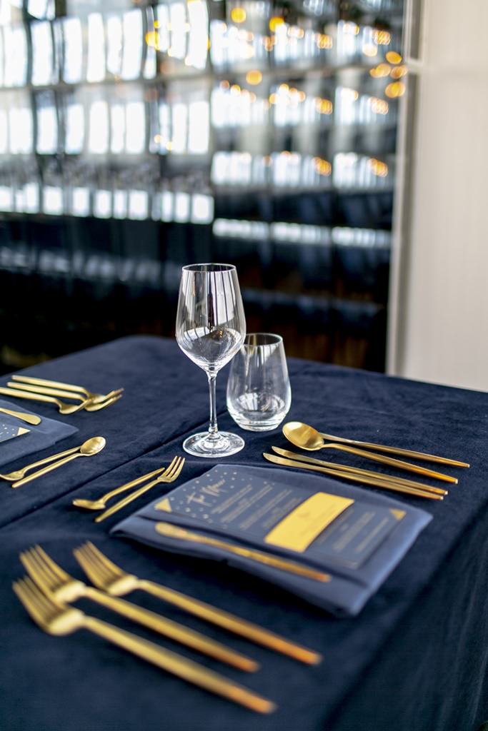 Hochzeitstischdeko mit blauer Tischdecke und goldenem Besteck