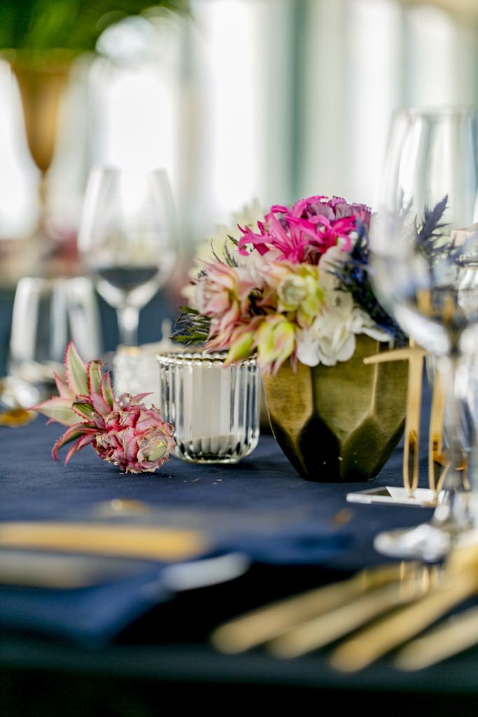 Hochzeitstischdeko mit dunkelblauer Tischdecke und Goldbesteck