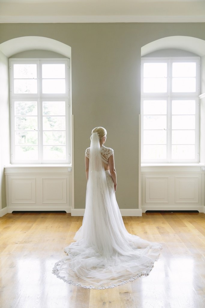 die fertig gestylte Braut steht in einem Zimmer von Schloss Körtlinghausen | Foto von Hanna Witte