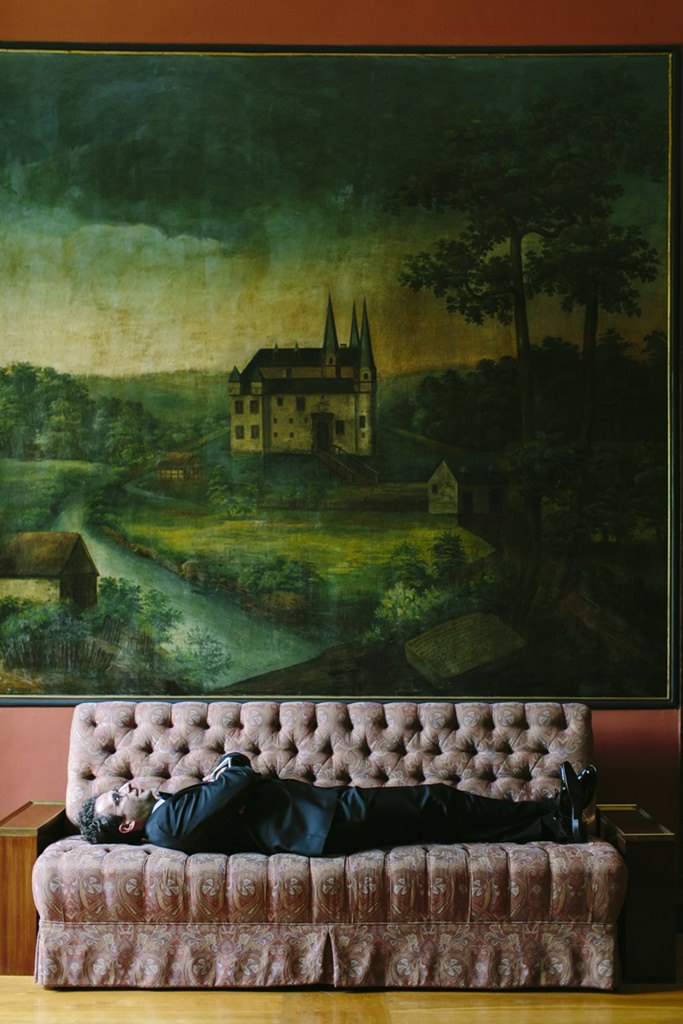 der Bräutigam liegt auf einem Sofa in Schloss Körtlinghausen | Foto von Hanna Witte