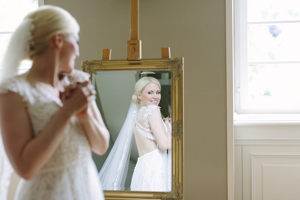 die Braut betrachtet sich beim Getting Ready im Spiegel | Foto von Hanna Witte
