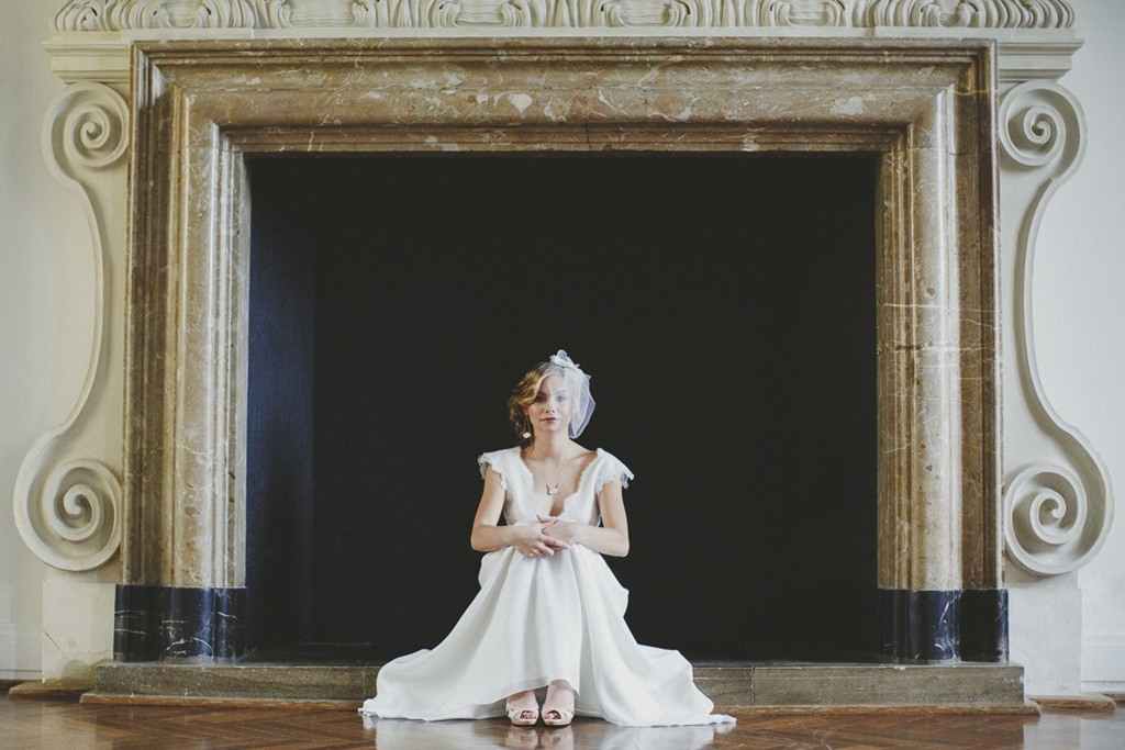 eine Braut sitzt vor einem großen Kamin im Schloss Benrath | Foto: Hanna Witte