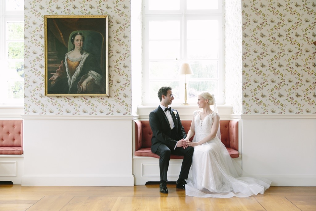 Hochzeitsfoto vom Brautpaar neben einem antiken Gemälde in einem Raum von Schloss Körtlinghausen | Foto von Hanna Witte