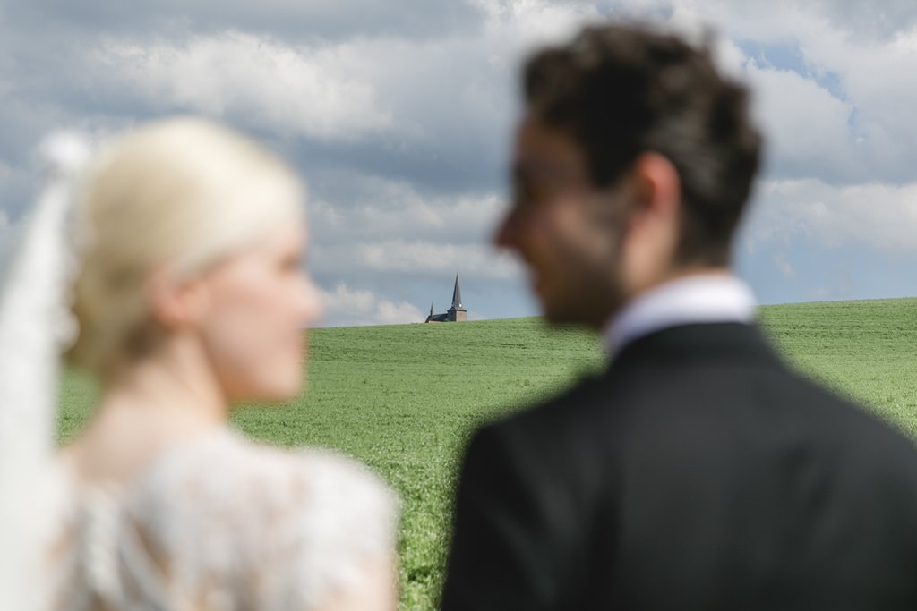 kreatives Hochzeitsfoto von Braut und Bräutigam auf einem Feld | Foto von Hanna Witte