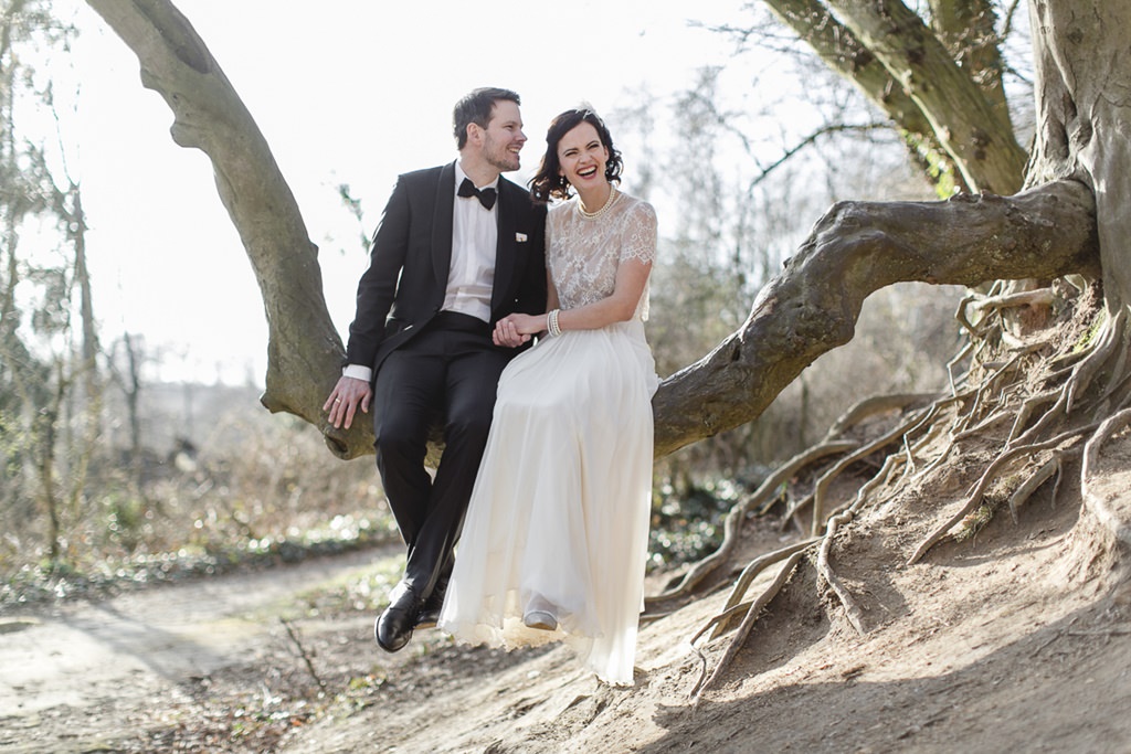 Hochzeitsfotoidee: Braut und Bräutigam sitzen auf einem entwurzelten Baum | Foto: Hanna Witte
