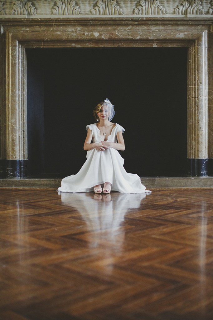 eine Braut sitzt vor einem großen Kamin von Schloss Benrath | Foto: Hanna Witte