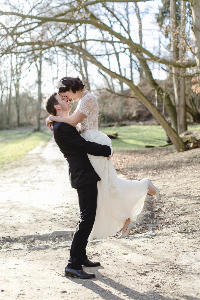 der Bräutigam hebt die Braut in einem winterlichen Park hoch | Foto: Hanna Witte