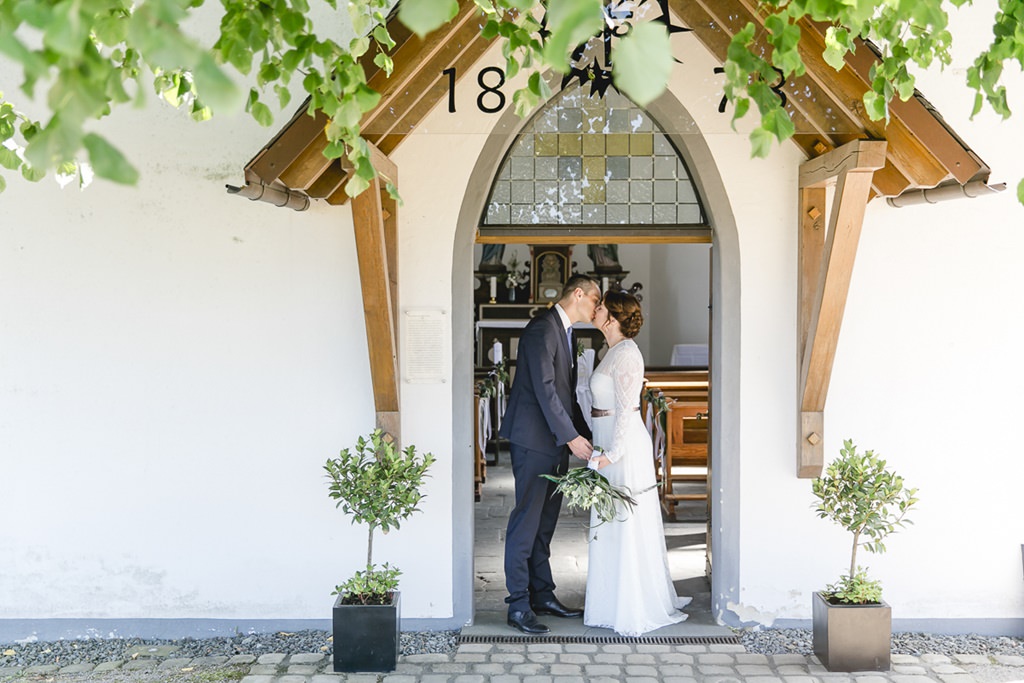 Paarfoto von Braut und Bräutigam vor dem Eingang zur Kapelle | Foto von Hochzeitsfotografin Hanna Witte