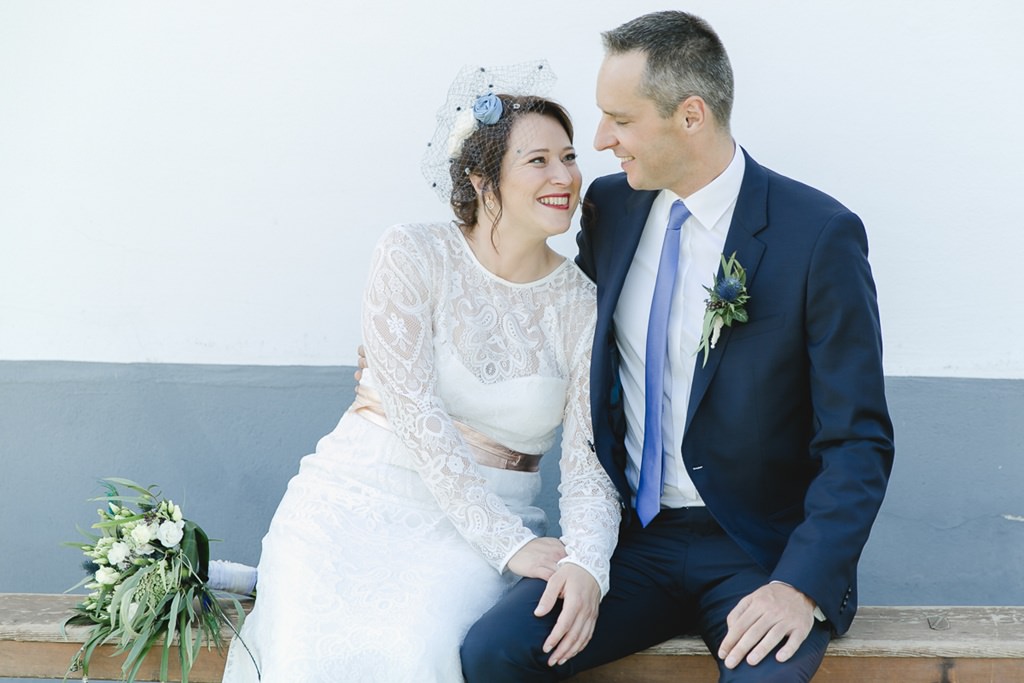 klassisches Paarfoto von Braut und Bräutigam, die nebeneinander auf einer Bank sitzen | Foto von Hochzeitsfotografin Hanna Witte