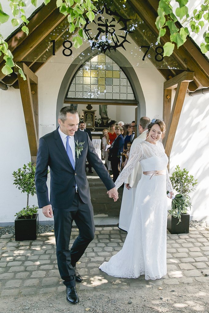 Hochzeitsbild von Braut und Bräutigam beim Auszug aus der Kirche