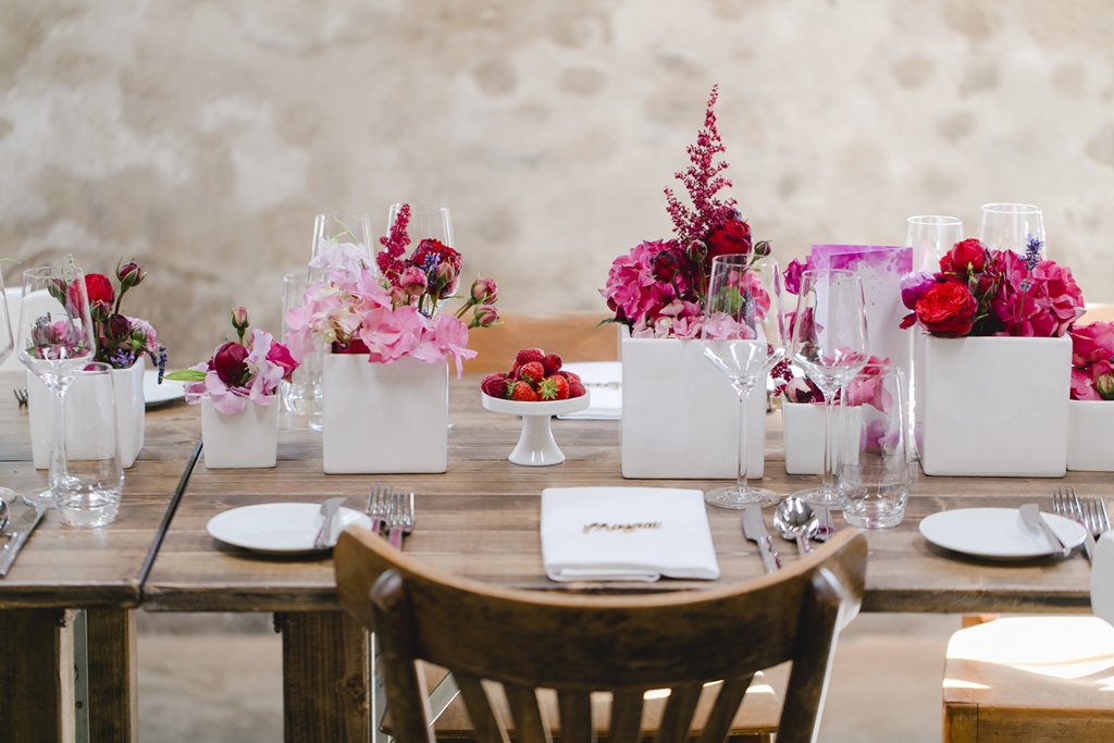 Hochzeitsdeko mit rustikalen Holztischen und Deko in Weiß und Pink | Foto: Hanna Witte