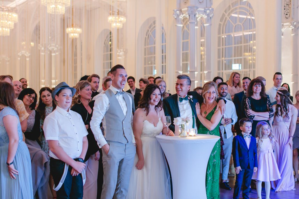das Brautpaar lacht mit seinen Gästen ährend der Hochzeitsfeier | Foto: Hanna Witte