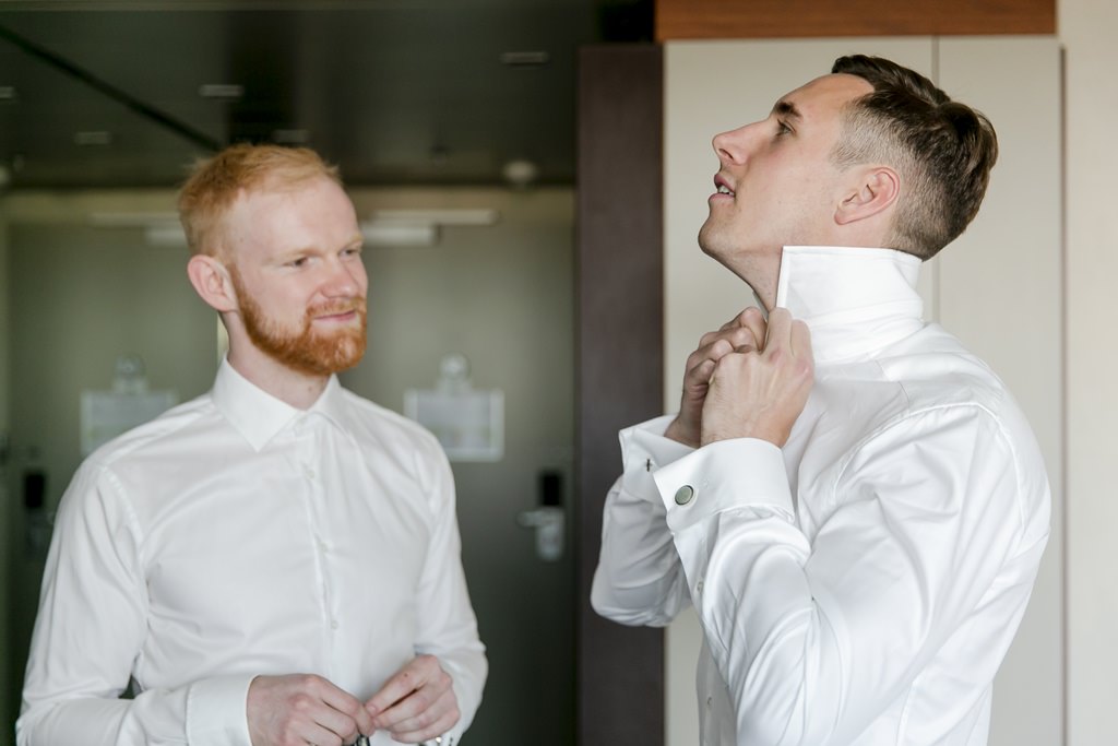 der Bräutigam knöpft sich beim Getting Ready das Hemd zu | Foto: Hanna Witte
