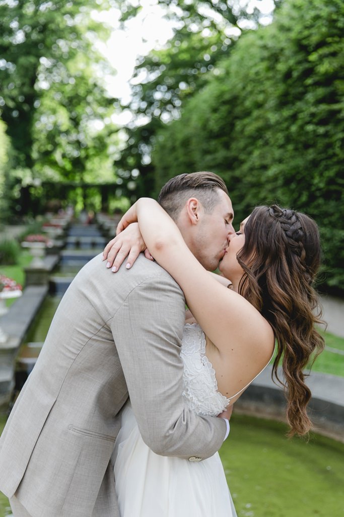 das Brautpaar küsst sich beim Paarshooting im Garten der Flora Köln | Foto: Hanna Witte