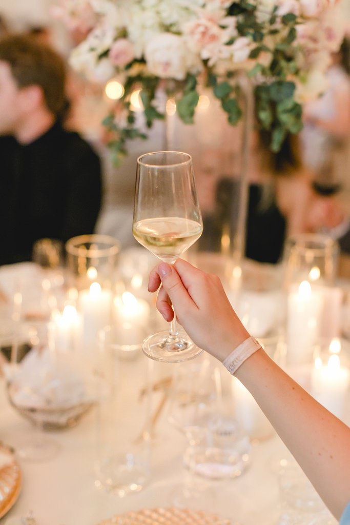 ein Hochzeitsgast hält während der Feier ein Weinglas zum Anstoßen hoch | Foto: Hanna Witte