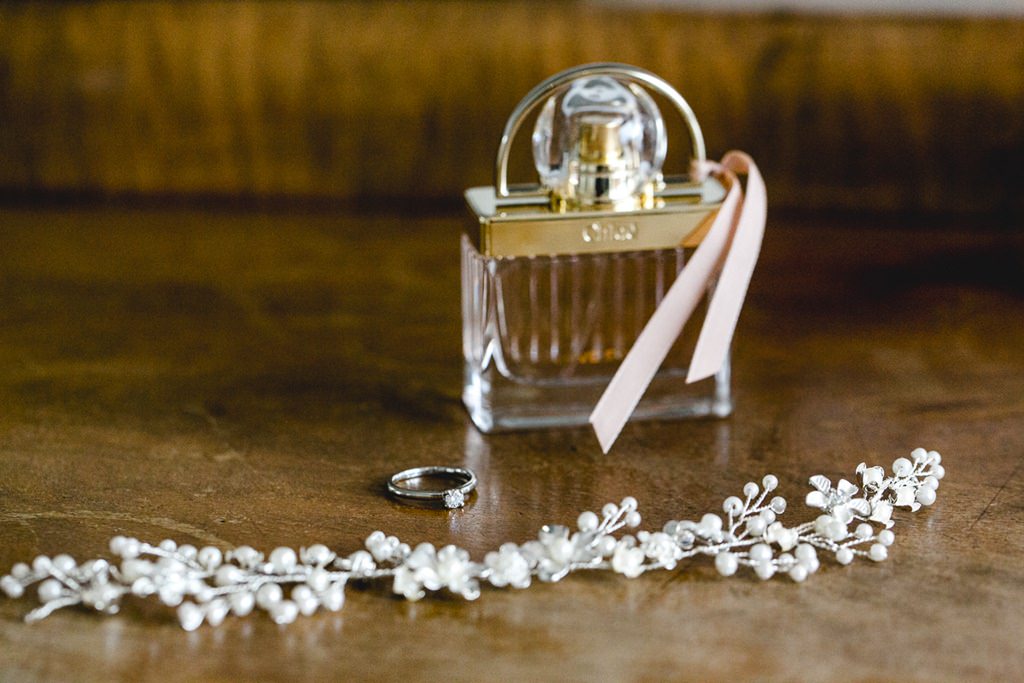 Hochzeitsfoto der Brautaccessoires Parfum, Verlobungsring und Haarschmuck | Foto: Hanna Witte
