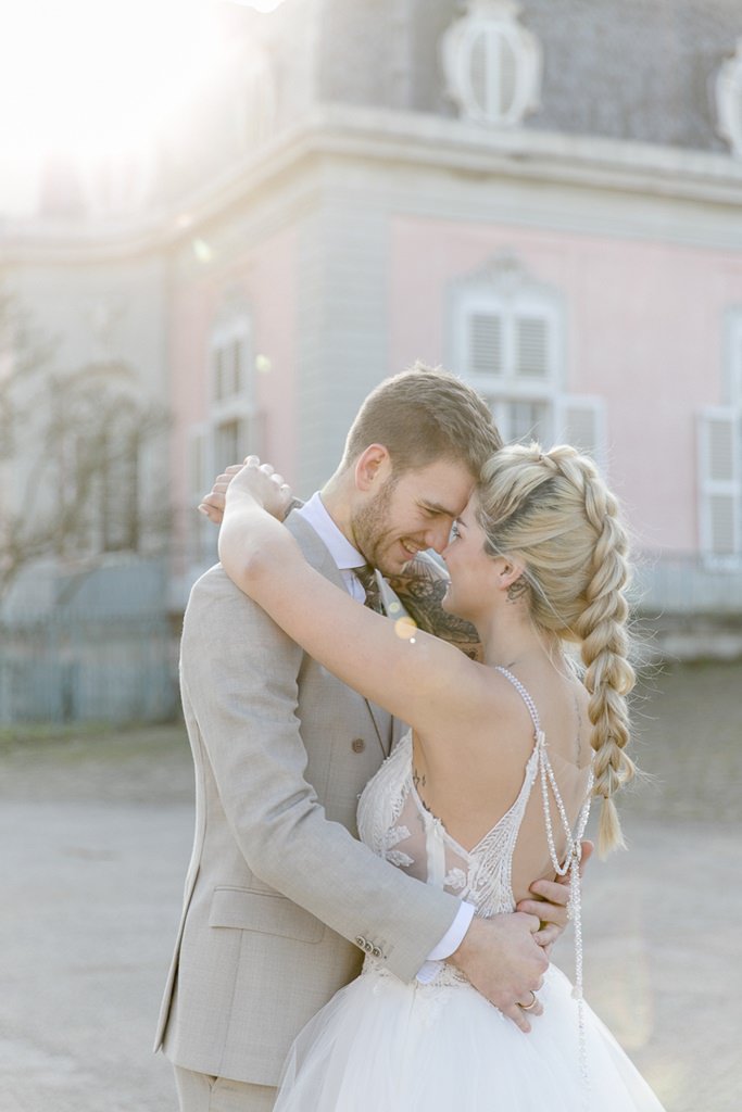 emotionales Hochzeitsfoto von Braut und Bräutigam vor Schloss Benrath | Foto: Hanna Witte