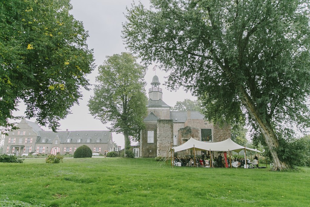 Freie Trauung draußen unter einem Stretchzelt auf einer Wiese von Schloss Hertefeld | Foto: Hanna Witte