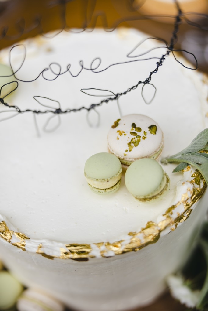 weiße Hochzeitstorte mit Blattgold Deko und Macarons | Bild: Hochzeitsfotografin Hanna Witte