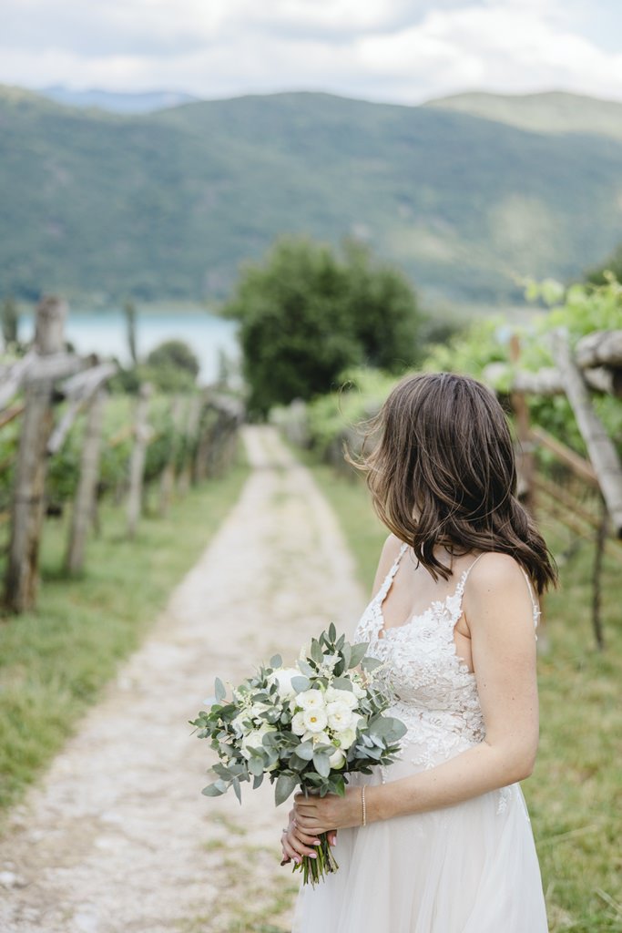 die Braut steht auf einem Feldweg zwischen Weinreben | Bild: Hochzeitsfotografin Hanna Witte