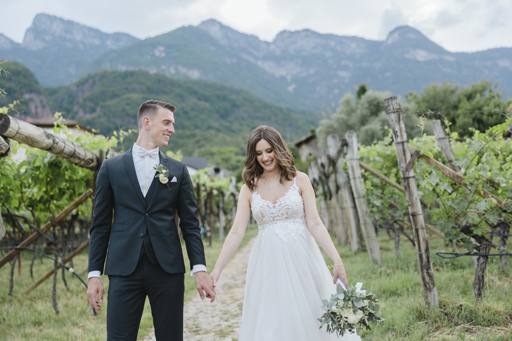 Braut und Bräutigam laufen Hand in Hand durch die Weinberge in Südtirol | Bild: Hochzeitsfotografin Hanna Witte