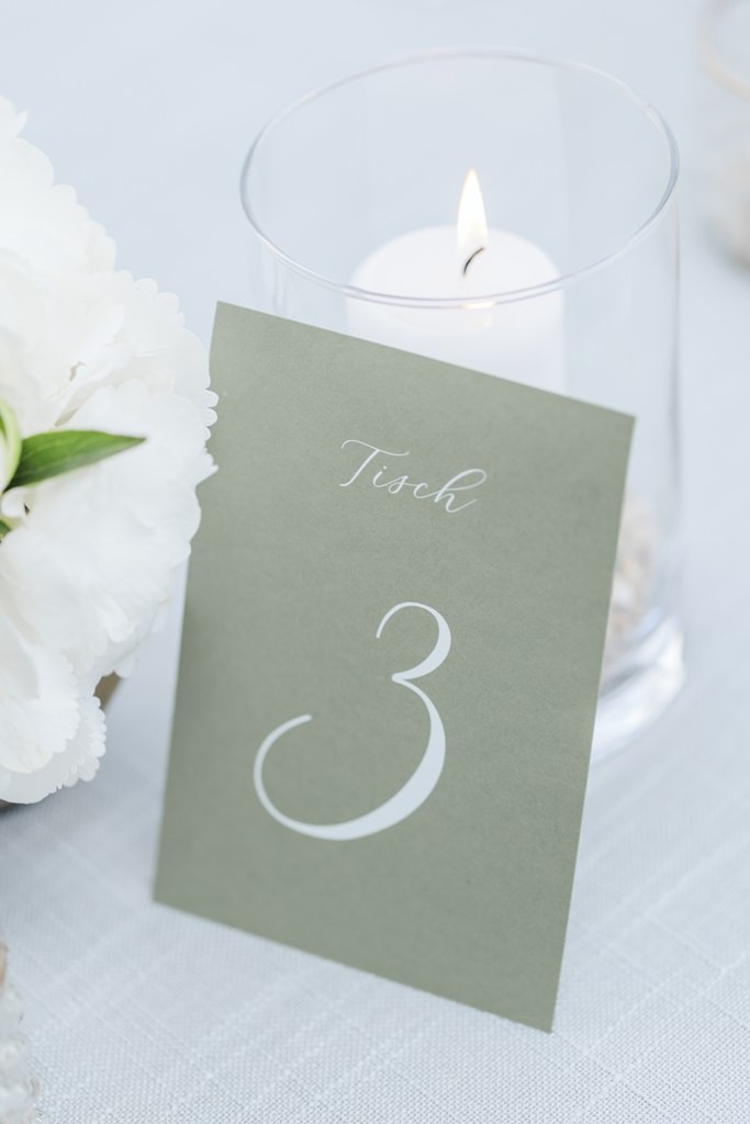 hellgrüne Karte mit weißer Tischnummer als Teil der Hochzeitsdeko | Bild: Hochzeitsfotografin Hanna Witte
