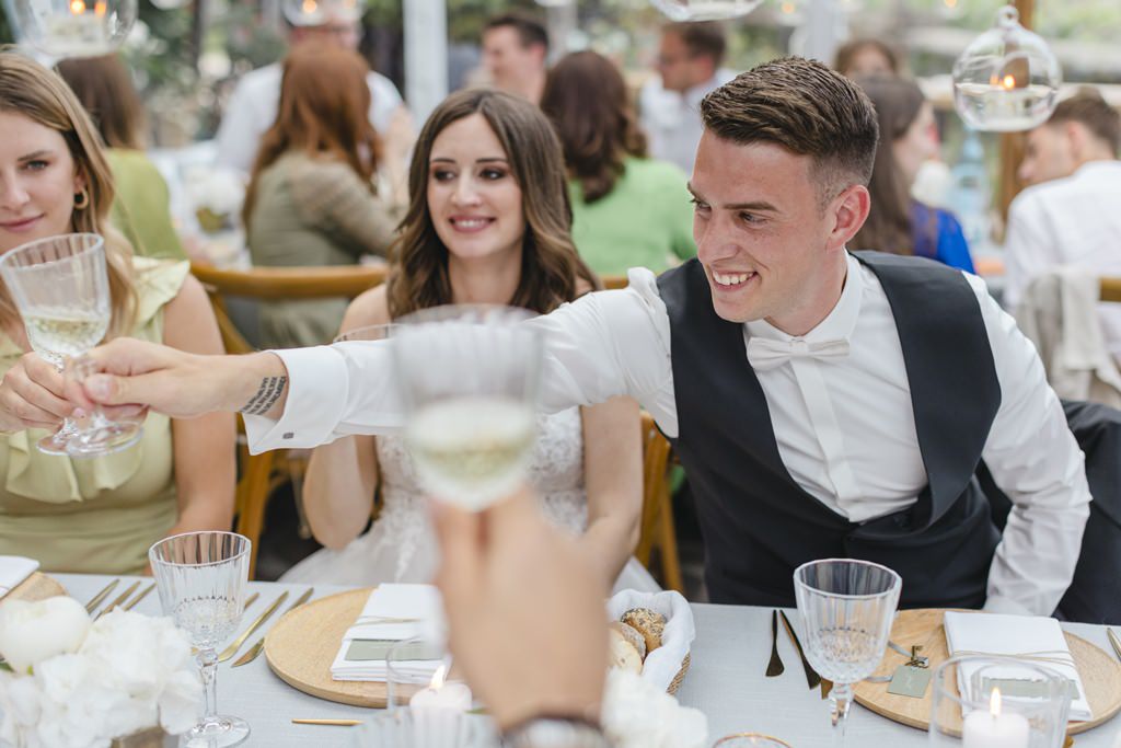 der glückliche Bräutigam stößt während des Dinners mit den Hochzeitsgästen an | Bild: Hochzeitsfotografin Hanna Witte