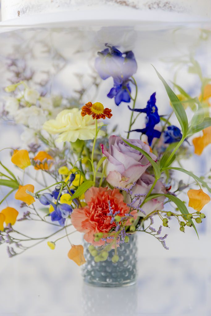 bunte Hochzeits-Blumendeko in blau, gelb, orange und lila | Foto: Hanna Witte