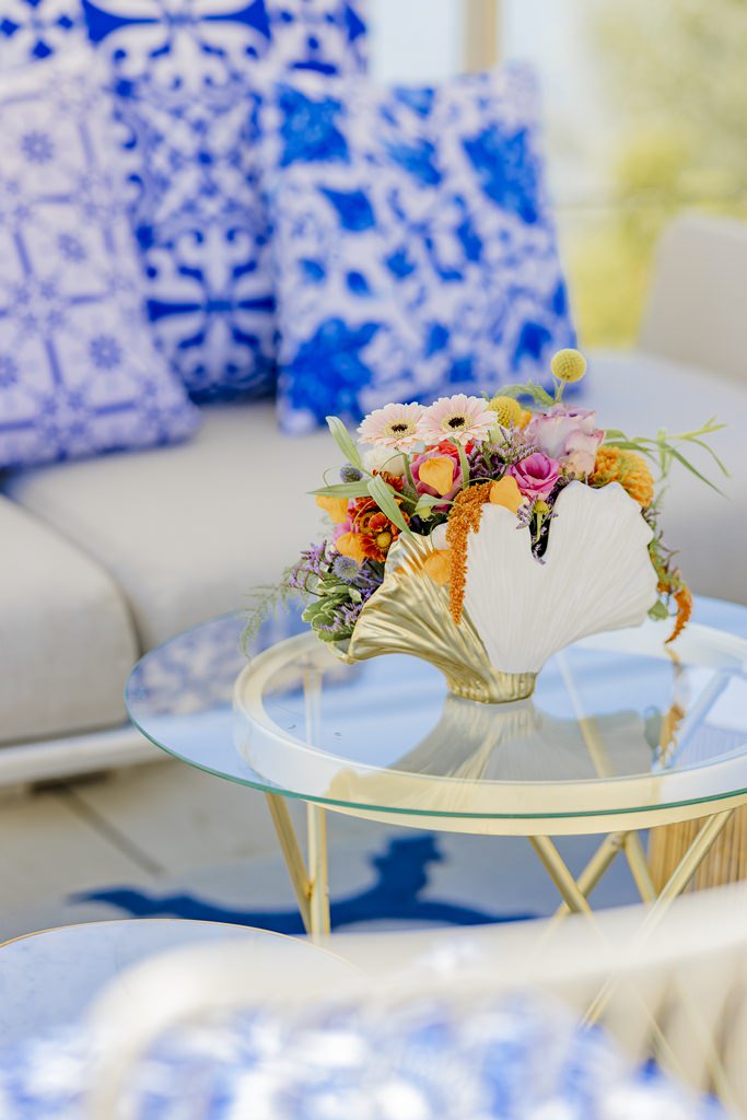 Hochzeitsdeko mit weiß-goldener Vase in Muschelform, gefüllt mit bunten Blumen | Foto: Hanna Witte