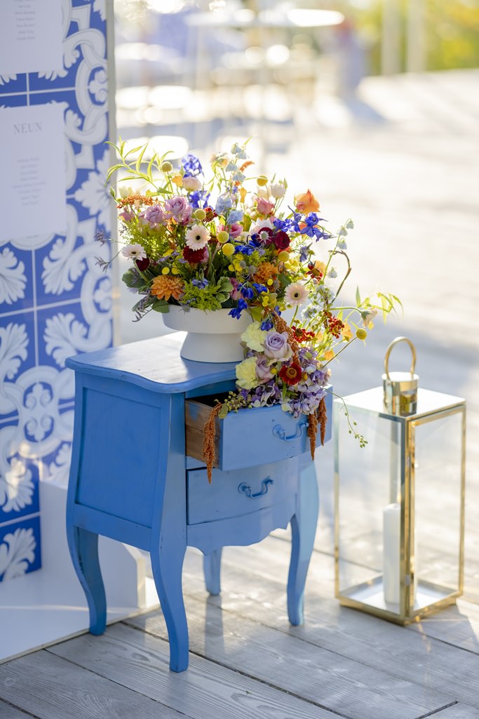 Hochzeitsdeko mit bunten Blumen, blauem Schränkchen und Gold-Laterne | Foto: Hanna Witte