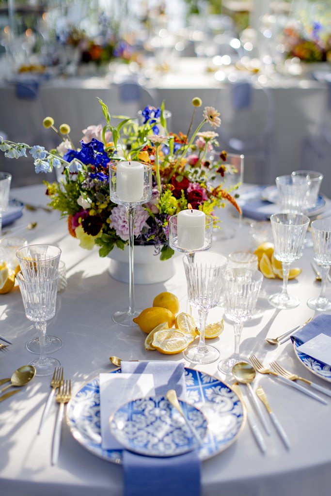 runder Hochzeitstisch mit bunter Floristik und blau-weißen Tellern | Foto: Hanna Witte