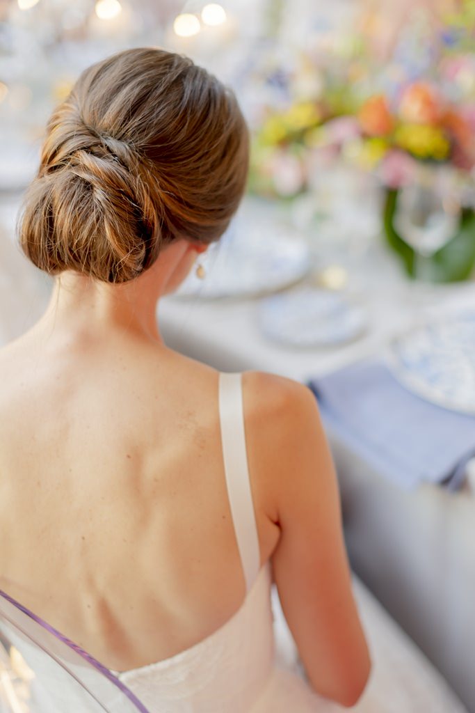 Rückenansicht der Braut, die während der Feier am Tisch sitzt | Foto: Hanna Witte