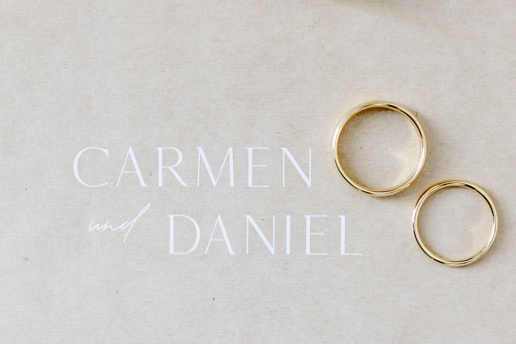 die schlichten goldenen Eheringe liegen auf einer Karte mit den Namen des Brautpaares | Foto: Hanna Witte