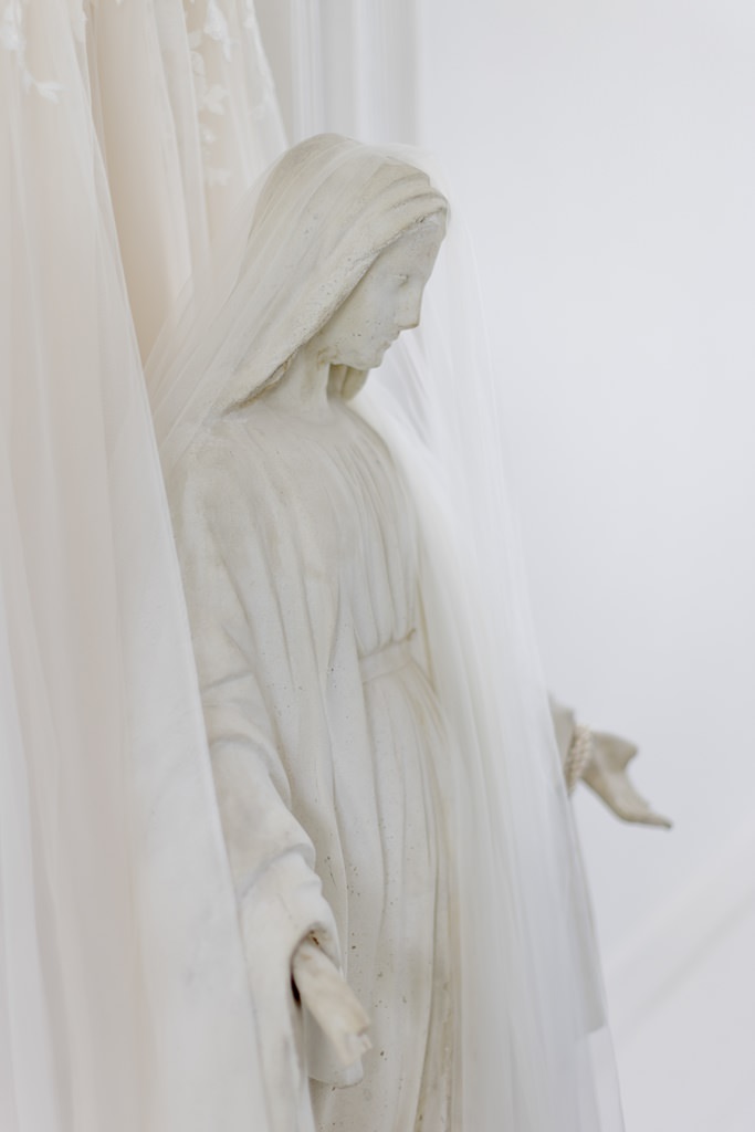 das Brautkleid hängt hinter einer Steinfigur | Foto: Hanna Witte