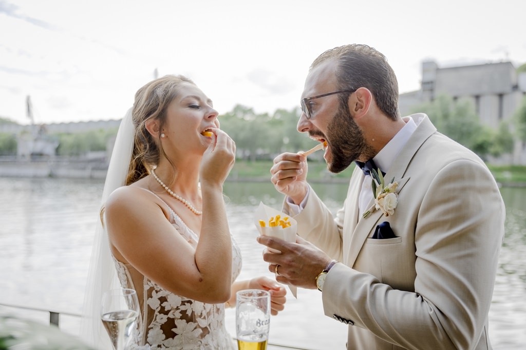 das Brautpaar isst beim Sektempfang gemeinsam Pommes | Foto: Hanna Witte