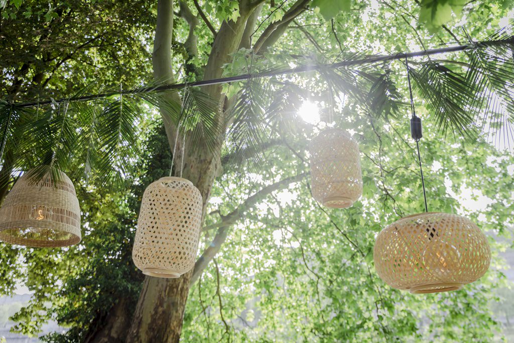 verschiedene Rattan Lampenschirme hängen über den Hochzeitstischen | Foto: Hanna Witte