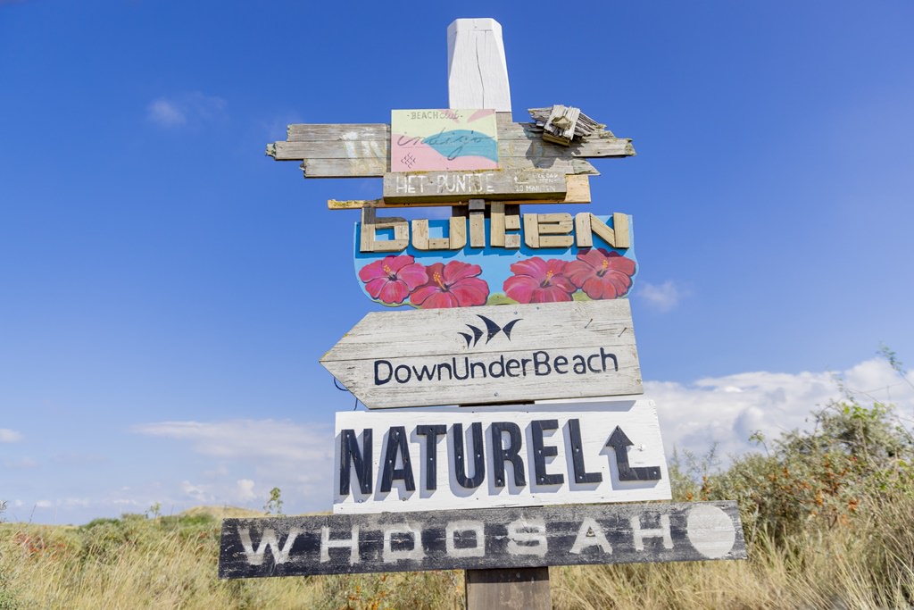rustikaler Wegweiser mit Schild vom Beachclub Naturel | Foto: Hanna Witte